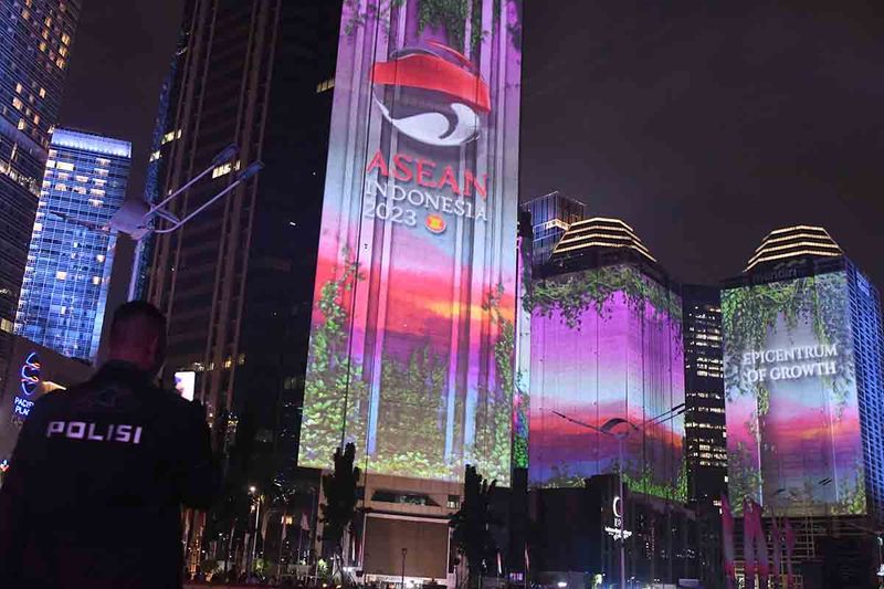 Petugas kepolisian berjaga dengan latar belakang pertunjukan video mapping saat Gala Dinner KTT ke-43 ASEAN 2023 di Senayan, Jakarta, Rabu (6/9/2023). ANTARA FOTO/Media Center KTT ASEAN 2023/Dhoni Setiawan