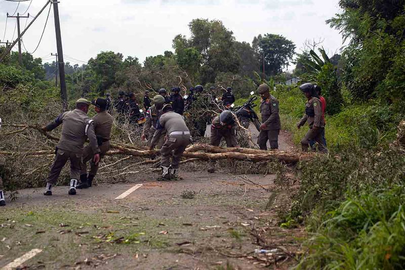 Sejumlah petugas yang tergabung dalam Tim Terpadu membersihkan pemblokiran jalan yang dilakukan oleh warga Pulau Rempang, Batam, Kepulauan Riau, Jumat (8/9/2023). Aksi pemblokiran jalan tersebut terkait pengembangan Pulau Rempang menjadi kawasan ekonomi baru dan rencana pemerintah yang akan merelokasi mereka ke wilayah lain. ANTARA FOTO/Teguh Prihatna