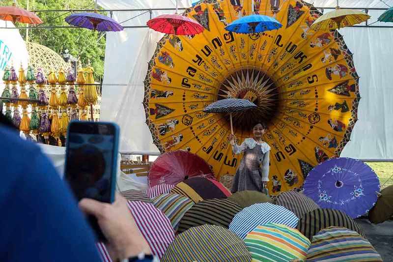 Pengunjung berfoto dengan beragam kerajinan payung saat pembukaan Festival Payung Indonesia 2023 di Balai Kota Solo, Jawa Tengah, Jumat (8/9/2023). Festival yang mengangkat tema Sepayung Bumi, Alam Adalah Kita tersebut menampilkan beragam kerajinan payung dan kelompok pertunjukkan seni dari Indonesia, Thailand, India, Jepang, dan Equador. ANTARAFOTO/Maulana Surya