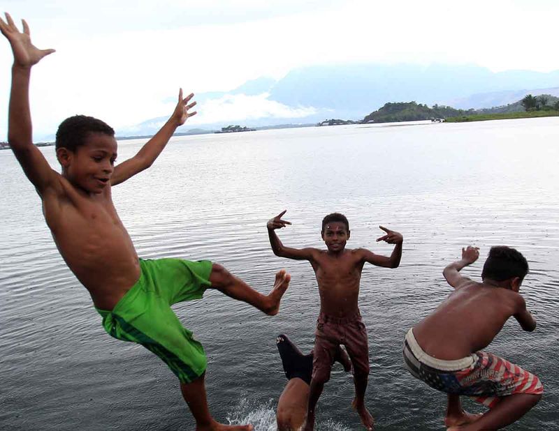 Sejumlah anak-anak melompat ke Danau Sentani di Kampung Abar, Jayapura, Papua, Sabtu (9/9/2023). Minimnya lahan bermain yang layak di kampung tersebut manjadikan Danau Sentani tempat favorit untuk bermain bagi anak-anak yang tinggal di sekitar danau itu. ANTARA FOTO/Gusti Tanati