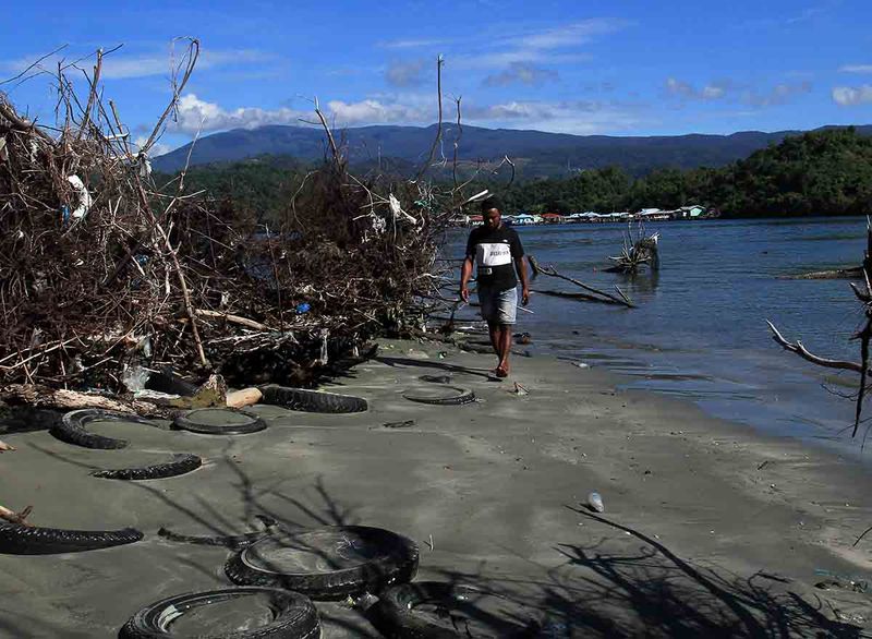 Warga berjalan di tepi Pantai Ciberi yang terdampak abrasi di Pantai Ciberi, Kota Jayapura, Papua, Senin (11/9/2023). Sejumlah titik di pantai tersebut terdampak abrasi akibat gelombang laut sehingga menganggu kenyamanan wisatawan lokal maupun mancanegara yang berkunjung di daerah tersebut. ANTARA FOTO/Gusti Tanati