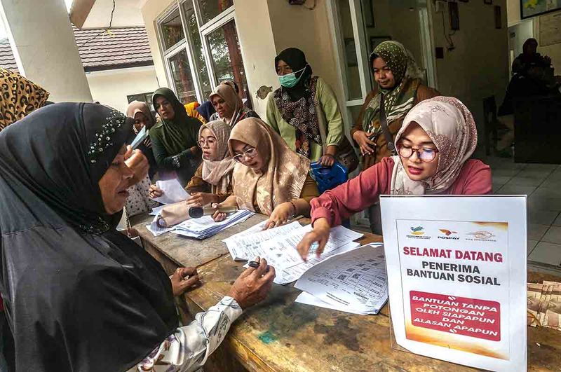 Petugas mendata warga penerima bantuan saat pencairan tunai Bantuan Sosial (Bansos) di Desa Cigadung, Pandeglang, Banten, Senin (11/9/2023). Kementerian Sosial merealisasi penyerapan anggaran untuk Program Keluarga Harapan (PKH) hingga Agustus 2023 mencapai 64 persen atau Rp51,11 triliun dari total anggaran sebesar Rp79,41 triliun. ANTARA FOTO/Muhammad Bagus Khoiruans