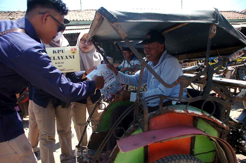 Sejumlah anggota KPU menunjukkan partai - partai peserta Pemilu 2024 kepada tukang becak saat sosialisasi Pemilu 2024 di Pasar Suradadi, Kabupaten Tegal, Jawa Tengah, Senin (11/9/2023). Sosialisasi oleh Komisi Pemilihan Umum (KPU) Kabupaten Tegal tersebut untuk memberikan edukasi serta meningkatkan partisipasi masyarakat agar menggunakan hak suara pada 14 Februari mendatang. ANTARA FOTO/Oky Lukmansyah