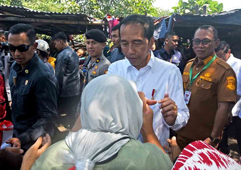 Presiden Joko Widodo (kedua kanan) didampingi Wali Kota Cilegon Heldi Agustian (kanan) menyalami pedagang di Pasar Kranggot Kota Cilegon, Selasa (12/9/2023). Dalam kunjungannya itu Presiden mengecek harga-harga kebutuhan pokok dan membagikan bantuan langsung tunai (BLT) kepada warga. ANTARA FOTO/Asep Fathulrahman