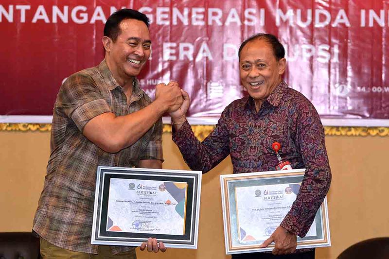 Mantan Panglima TNI Jenderal TNI (Purn) Andika Perkasa (kiri) berjabat tangan dengan Dekan Fakultas Hukum Universitas Udayana Putu Gede Arya Sumerta Yasa (kanan) saat kegiatan kuliah umum bertema Tantangan Generasi Muda Indonesia di Era Disrupsi, di Universitas Udayana, Denpasar, Bali, Selasa (12/9/2023). Pada kesempatan itu, Andika Perkasa memberikan motivasi kepada para mahasiswa yang akan menjadi generasi penerus untuk membawa kemajuan bangsa. ANTARA FOTO/Fikri Yusuf