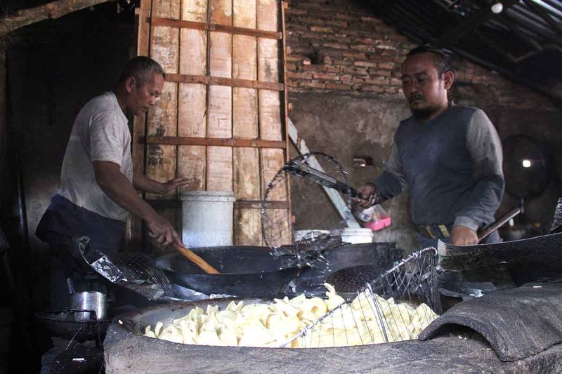 Pekerja menggoreng kerupuk uyel di home industri Desa Sumberagung, Kecamatan Megaluh, Kabupaten Jombang, Jawa Timur, Selasa (12/9/2023). Saat musim kemarau kualitas kerupuk lebih bagus dan cepat kering karena mengandalkan sinar matahari, dalam sehari bisa memproduksi sekitar tiga kuintal kerupuk yang dijual Rp26 ribu per kilogram. ANTARA FOTO/Syaiful Arif