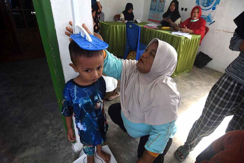 Petugas kesehatan mengukur tinggi badan anak balita saat pelaksanaan Pos Pelayanan Terpadu (Posyandu) di Palu, Sulawesi Tengah, Selasa (12/9/2023). Pemerintah daerah setempat berupaya memantau pertumbuhan anak balita dengan meningkatkan pelayanan posyandu sebagai deteksi dini stunting guna mendukung target tingkat stunting secara nasional di bawah 14 persen pada 2024 . ANTARA FOTO/Mohamad Hamzah