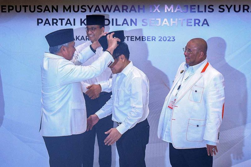 Presiden Partai Keadilan Sejahtera (PKS) Ahmad Syaikhu (kiri) didampingi Sekjen PKS Aboe Bakar Alhabsyi (kanan) memakaikan peci ke bakal calon wakil presiden Muhaimin Iskandar (kedua kanan) dan bakal calon presiden Anies Baswedan (kedua kiri) usai Rapat Majelis Syuro PKS di kantor DPP PKS, Pasar Minggu, Jakarta, Jumat (15/9/2023). Rapat tersebut menghasilkan kepastian dukungan PKS terhadap pencalonan Ketua Umum PKB Muhaimin Iskandar sebagai pasangan Anies Baswedan dalam Pemilu Presiden 2024. ANTARA FOTO/Aditya Pradana Putra