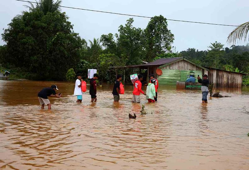 Sejumlah relawan membawa logistik untuk dibagikan kepada warga yang terdampak banjir di Desa Waleh, Kecamatan Weda Utara, Kabupaten Halmahera Tengah, Maluku Utara, Jumat (15/9/2023). Akibat curah hujan yang tinggi sejak Kamis (14/9) malam membuat air sungai Waleh meluap ke pemukiman warga dan terdapat 78 kepala keluarga (KK) mengungsi karena rumah mereka terendam banjir setinggi 1,5 meter. ANTARA FOTO/Adlun Fiqri