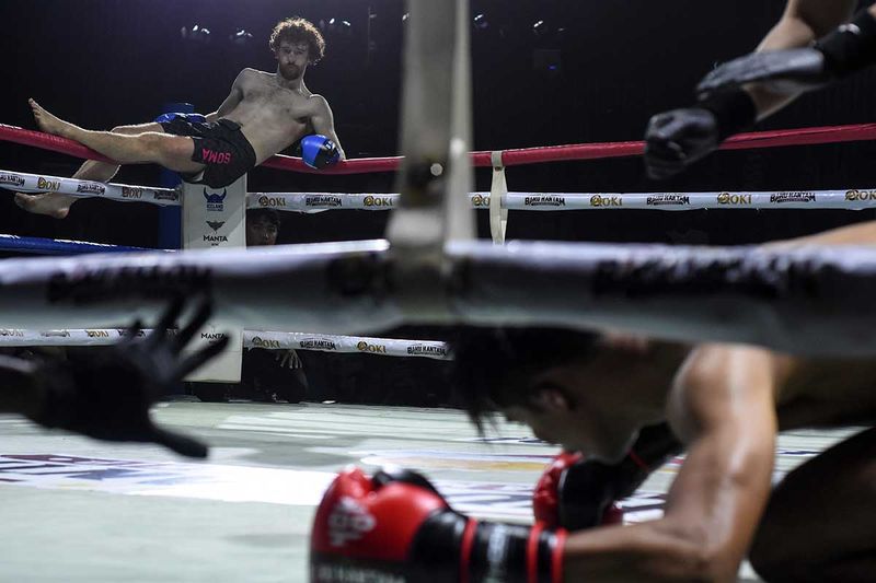 Petarung asal Irlandia Aaron Clarke (kiri) berselebrasi usai menjatuhkan lawannya petarung asal Indonesia Sony Rizaldi (kanan) pada pertandingan Baku Hantam Championship di Balai Sarbini, Jakarta, Sabtu (16/9/2023) malam. Baku Hantam Championship merupakan ajang kejuaraan beladiri yang menyajikan pertandingan Boxing, Kick Boxing, dan tarung bebas atau Mixed Martial Arts (MMA) sebagai wadah bagi para atlit Indonesia untuk mengasah bakat-bakat baru di tarung bebas Indonesia agar bisa naik kelas ke tingkat Internasional. ANTARA FOTO/Indrianto Eko Suwarso