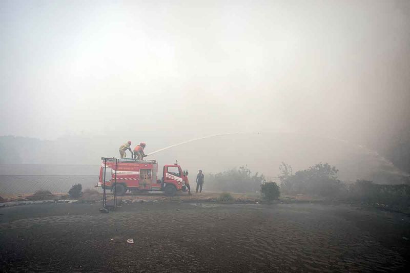 Petugas Pemadam Kebakaran berusaha memadamkan api yang membakar gunungan sampah di TPA Putri Cempo, Solo, Jawa Tengah, Minggu (17/9/2023). Kebakaran tersebut diduga karena cuaca panas yang memicu gas metan di dalam sampah, sedangkan luasan gunungan sampah yang terbakar diperkirakan mencapai dua hektar. ANTARA FOTO/Mohammad Ayudha