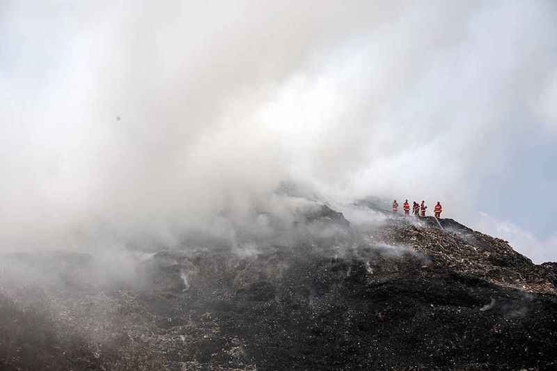 Petugas Pemadam Kebakaran berusaha memadamkan api yang membakar gunungan sampah di TPA Putri Cempo, Solo, Jawa Tengah, Minggu (17/9/2023). Kebakaran tersebut diduga karena cuaca panas yang memicu gas metan di dalam sampah, sedangkan luasan gunungan sampah yang terbakar diperkirakan mencapai dua hektar. ANTARA FOTO/Mohammad Ayudha