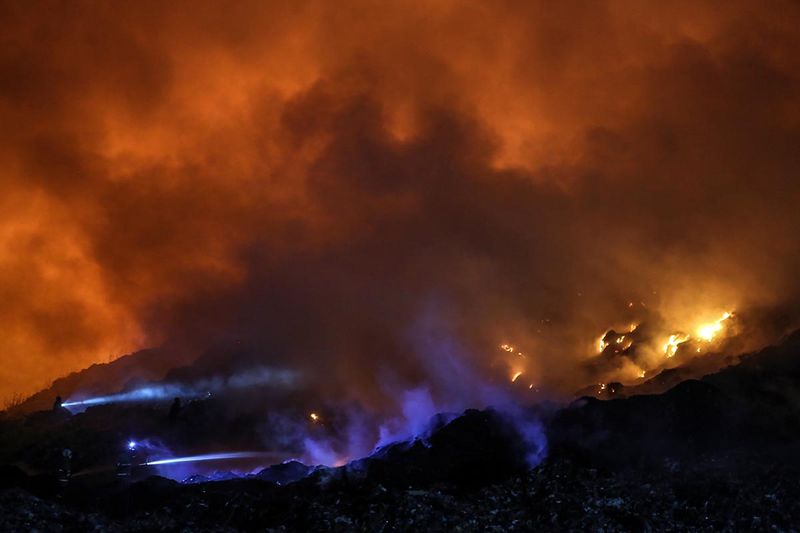 Petugas pemadam kebakaran melakukan pembasahan kebakaran sampah di tempat pembuangan akhir (TPA) Jatibarang, Semarang, Jawa Tengah, Senin (18/9/2023). Kebakaran di kawasan seluas dua hektare yang merupakan TPA tidak aktif tersebut terjadi pada pukul 14.00 WIB dan petugas gabungan Polri, Dinas Pemadaman Kebakaran, BPBD, dan PDAM setempat masih melakukan proses pemadaman. ANTARA FOTO/Makna Zaezar