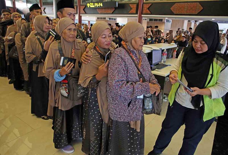 Petugas memeriksa tiket jamaah umroh yang akan menaiki pesawat dalam penerbangan perdana "Umroh Full Service" di Terminal 2, Bandara Soekarno Hatta, Tangerang, Banten, Senin (18/9/2023). Lion Group bekerja sama dengan biro perjalanan haji dan umroh PT Bumi Tunggal Wisata mulai membuka penerbangan "Umroh Full Service" di mana jemaah mendapatkan pelayanan penuh mulai dari penerbangan, penginapan hingga seluruh rangkaian ibadah umroh selama di Tanah Suci. ANTARA FOTO/Muhammad Iqbal