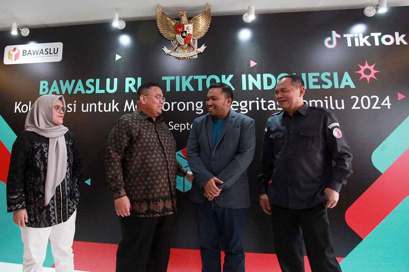 Ketua Bawaslu Rahmat Bagja (kedua kiri) bersama anggota Bawaslu Lolly Suhenty (kiri), Head of Public Policy & Government Relations TikTok Indonesia Firry Wahid (kedua kanan), dan Sekretaris Jenderal Bawaslu Ichsan Fuady (kanan) berbincang usai penandatanganan kerja sama Bidang Pengawasan dan Penanganan Konten Disinformasi dalam Penyelenggaraan Pemilu di Kantor Bawaslu, Jakarta, Senin (18/9/2023). Bawaslu berkolaborasi dengan TikTok, platform hiburan digital, untuk melawan penyebaran misinformasi dan disinformasi (hoax) terkait Pemilu 2024 serta menyediakan informasi akurat, memantau, menangani konten disinformasi, dan mempercepat penyebaran informasi terkait Pemilu 2024. ANTARA FOTO/Reno Esnir