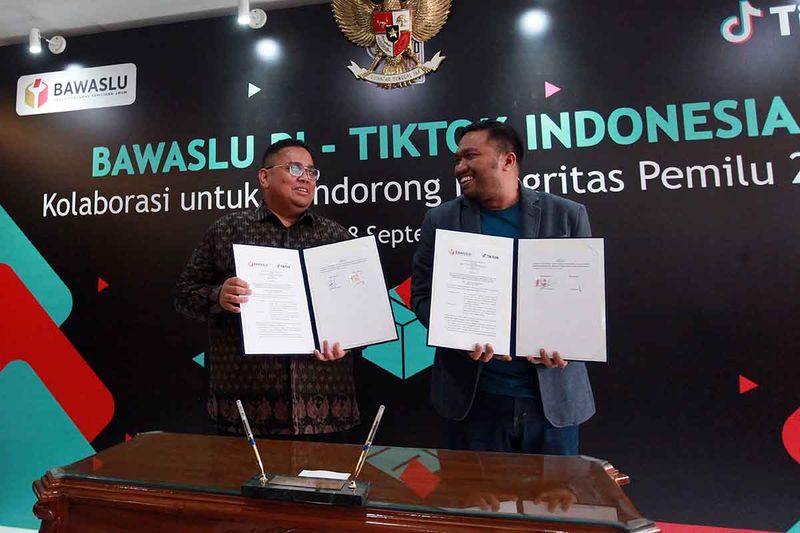 Ketua Bawaslu Rahmat Bagja (kiri) bersama Head of Public Policy & Government Relations TikTok Indonesia Firry Wahid (kanan) menunjukkan nota kerja sama Bidang Pengawasan dan Penanganan Konten Disinformasi dalam Penyelenggaraan Pemilu di Kantor Bawaslu, Jakarta, Senin (18/9/2023). Bawaslu berkolaborasi dengan TikTok, platform hiburan digital, untuk melawan penyebaran misinformasi dan disinformasi (hoax) terkait Pemilu 2024 serta menyediakan informasi akurat, memantau, menangani konten disinformasi, dan mempercepat penyebaran informasi terkait Pemilu 2024. ANTARA FOTO/Reno Esnir