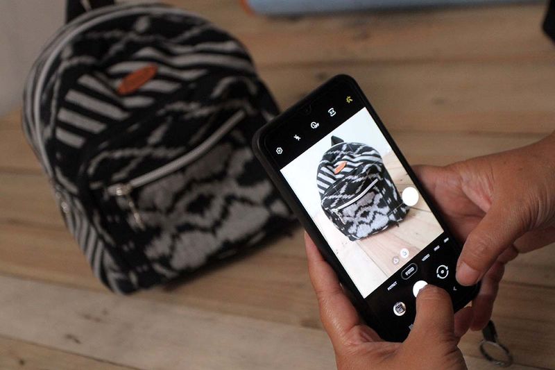 Perajin memotret tas dari potongan kain perca buatannya untuk diunggah di pasar digital di rumah produksi Dhititen, Malang, Jawa Timur, Selasa (19/9/2023). Perajin setempat memanfaatkan kain dari limbah industri konveksi tersebut untuk dibuat berbagai kerajinan seperti tas, dompet dan topi yang selanjutnya dijual ke berbagai kota di Indonesia melalui pasar digital dengan harga Rp35 ribu hingga Rp250 ribu tergantung model. ANTARA FOTO/Ari Bowo Sucipto