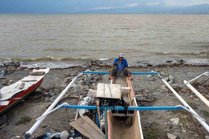 Nelayan memperbaiki pukatnya usai melaut di Pantai Kampung Lere, Palu, Sulawesi Tengah, Jumat (22/9/2023). Menurut data Otoritas Jasa Keuangan (OJK), realisasi penyaluran kredit produktif sektor perikanan di bank umum konvensional hingga semester I 2023 mencapai Rp19,974 triliun atau lebih tinggi 3,3 persen dari periode yang sama tahun sebelumnya yang senilai Rp19,331 triliun. ANTARA/Basri Marzuki
