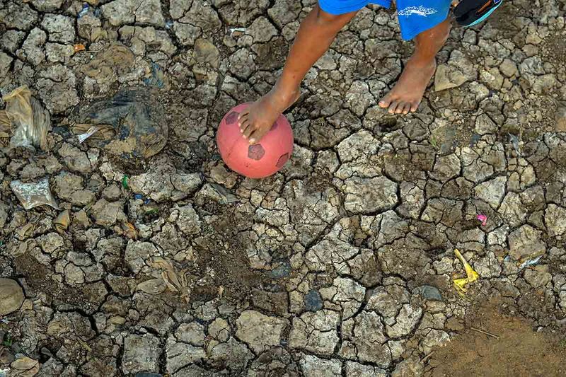 Seorang anak bermain bola di area Sungai Cikeruh yang mengering di Cileunyi Kulon, Rancaekek, Bandung, Jawa Barat, Jumat (22/9/2023). Sungai Cikeruh yang mengering akibat kemarau panjang yang melanda beberapa wilayah di Jawa Barat dimanfaatkan oleh anak-anak untuk bermain bola. ANTARA FOTO/Raisan Al Farisi