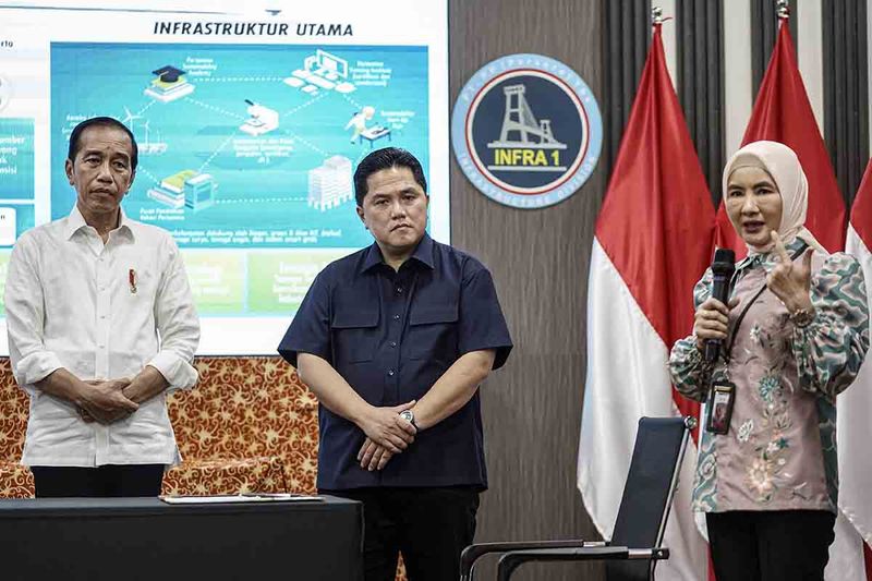 Presiden Joko Widodo didampingi Menteri BUMN Erick Thohir (tengah) mendengarkan paparan Dirut Pertamina Nicke Widyawati (kanan) saat penandatanganan nota kesepahaman pembangunan Pertamina Sustainable Energy Center (Pusat Energi Berkelanjutan) di Ibu Kota Nusantara (IKN), Penajam Paser Utara, Kalimantan Timur, Jumat (22/9/2023). Pertamina Sustainable Energy Center merupakan langkah untuk mendukung program Net Zero Emission (NZE) Pemerintah tahun 2060 dimana Pertamina mengembangkan pusat riset, green dan low carbon technology untuk Indonesia. ANTARA FOTO/Dhemas Reviyanto