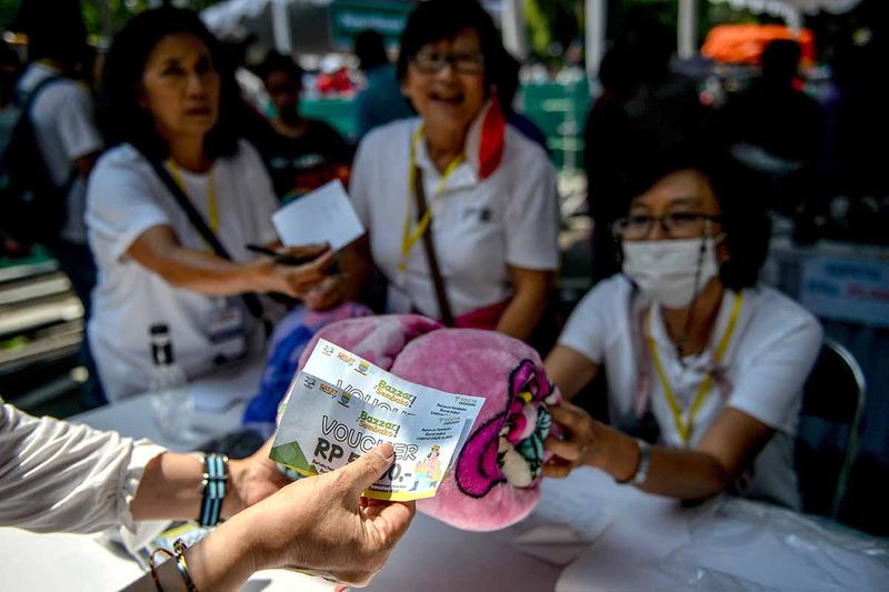 Warga menukarkan kupon untuk belanja pada bazaar bayar pakai sampah di Balai Kota Bandung, Jawa Barat, Sabtu (23/9/2023).Dalam rangka Hari Jadi ke-213 Kota Bandung, Pemerintah Kota Bandung menggelar bazaar bayar pakai sampah bagi warga yang ingin belanja sembako, pakaian, serta perlengkapan alas kaki dan tas dengan cara menukar sampah daur ulang dengan kupon. ANTARA FOTO/Raisan Al Farisi