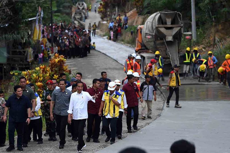 Presiden Joko Widodo (ketiga kiri) didampingi Menteri BUMN Erick Thohir (kiri) meninjau progres penanganan Inpres Jalan Daerah (IJD) di Desa Agro Mulyo, Kecamatan Sepaku, Kabupaten Penajam Paser Utara, Kalimantan Timur, Sabtu (23/9/2023). Presiden menyebut jalan sepanjang 8,3 Km tersebut nantinya akan menopang Ibu Kota Nusantara (IKN) sebagai jalan produksi dan akses menuju tempat wisata Gua Batu Tapak Raja. ANTARA FOTO/Sigid Kurniawan