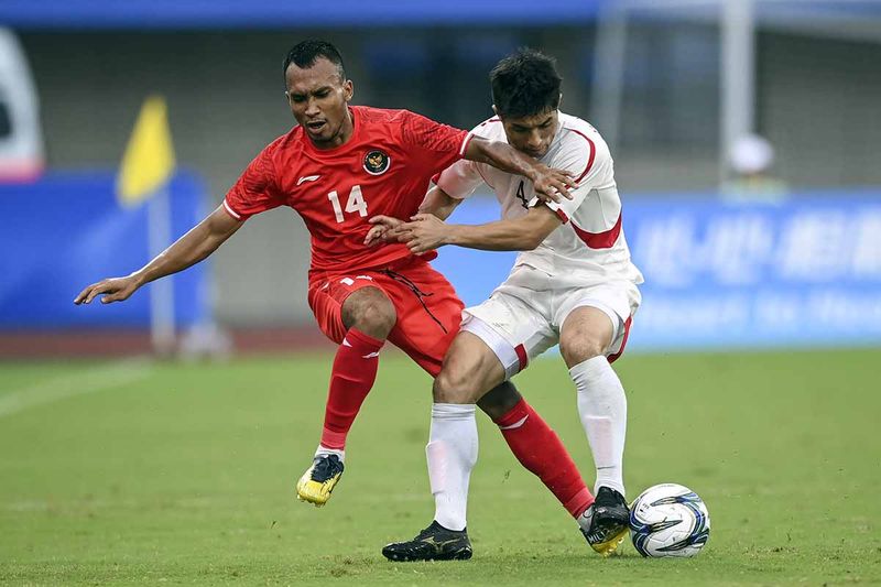 Pesepak bola Timnas U-24 Indonesia Robi Darwis (kiri) berusaha melewati pesepak bola Korea Utara Kim Pomhyok pada babak Grup F Asian Games 2022 di Zhejiang Normal University Stadium, Jinhua, China, Minggu (24/9/2023). Indonesia kalah dengan skor 0-1. ANTARA FOTO/Hafidz Mubarak A