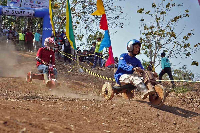 Peserta balap Gledekan beradu cepat saat Festival Gledekan Nusantara seri IV di sirkuit Kalisuren, Sidodadi, Patean, Kendal, Jawa Tengah, Minggu (24/9/2023). Balap Gledekan yang diikuti puluhan peserta tersebut bertujuan untuk melestarikan permainan tradisional yang mengandung nilai kekompakan tim dan sportivitas. ANTARA FOTO/Anis Efizudin