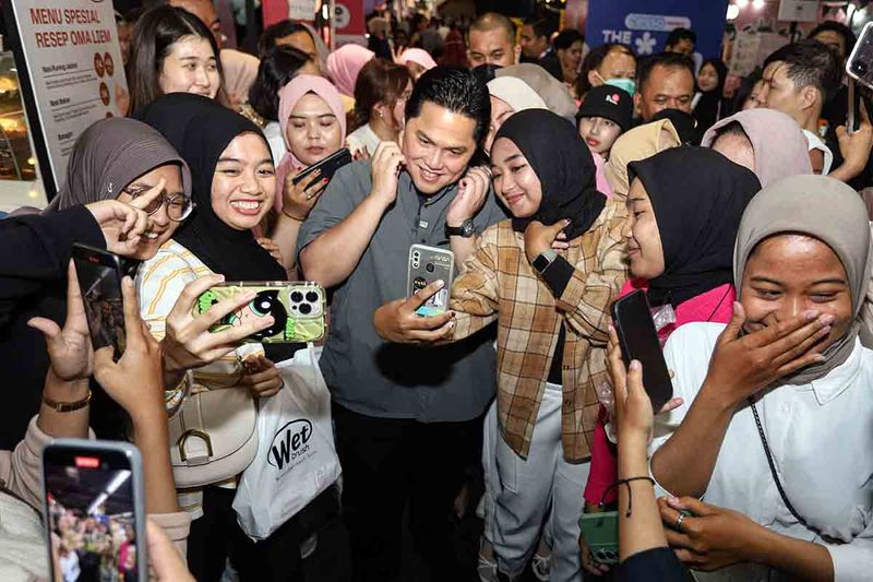 Menteri BUMN Erick Thohir (tengah) berswafoto dengan para pengunjung saat acara The Girl Fest 2023 di Surabaya, Jawa Timur, Minggu (24/9/2023). Dalam kegiatan tersebut Erick Thohir dan anaknya membagikan tips mengelola kesehatan mental bagi anak muda terutama perempuan dengan mendekatkan diri pada keluarga. ANTARA FOTO/Rizal Hanafi