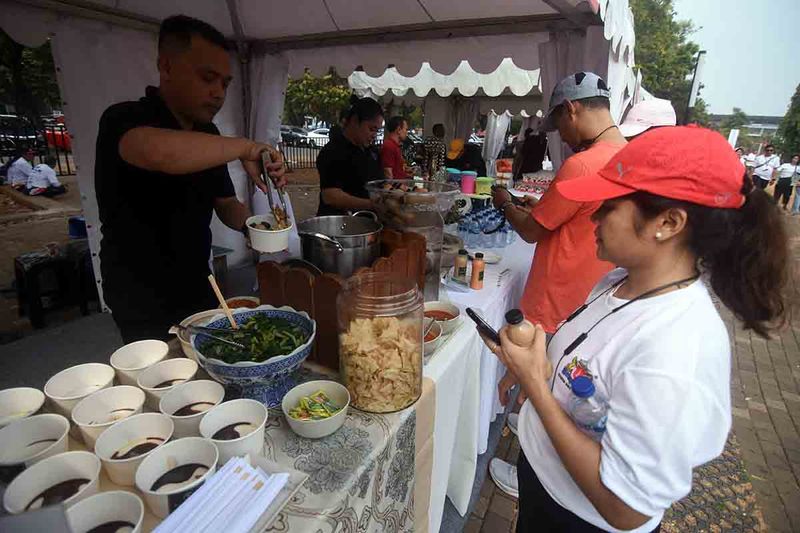 Pedagang melayani pembeli di salah satu stan umkm pada acara Fun Walk Kadin?Indonesia?di kawasan Gelora Bung Karno, Jakarta, Minggu (24/9/2023). Pameran UMKM Binaan Kadin Indonesia turut meramaikan perayaan HUT ke-55 Kadin Indonesia. ANTARA FOTO/Indrianto Eko Suwarso