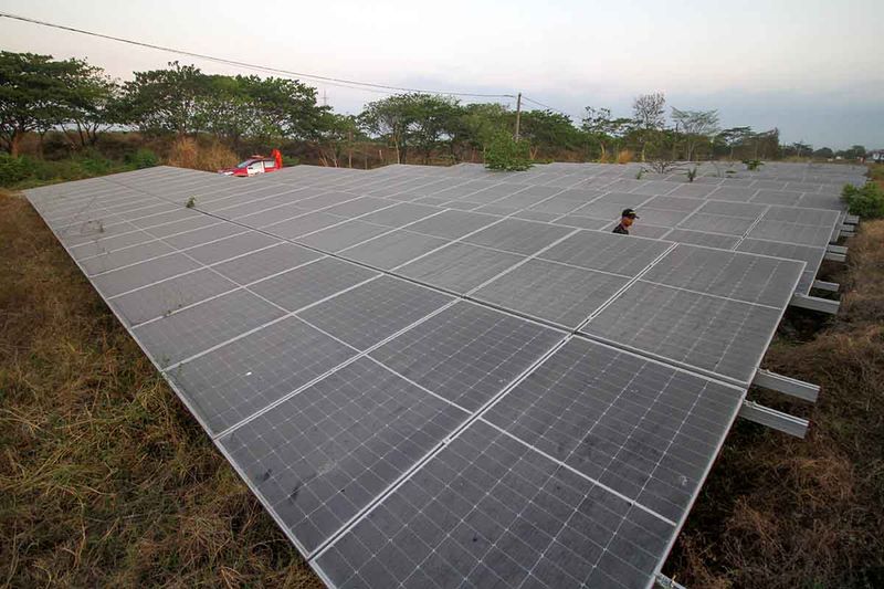 Warga melintasi area panel tenaga surya yang terpasang di kawasan Peta Area Terdampak (PAT) lumpur Lapindo, Porong, Sidoarjo, Jawa Timur, Minggu (24/9/2023). Berdasarkan survei dan kajian Badan Geologi Kementerian Energi dan Sumber Daya Mineral (ESDM) menyebutkan bahwa lumpur Lapindo mengandung potensi mineral logam tanah jarang (LTJ) atau rare earth element (REE) dan logam critical raw material (CRM) berupa kandungan Lithium (Li) yang bisa diolah menjadi bahan baku komponen teknologi baterai untuk kendaraan listrik maupun baterai dan pembangkit listrik berbasis energi baru terbarukan (EBT) seperti Pembangkit Listrik Tenaga Surya (PLTS). ANTARA FOTO/Umarul Faruq