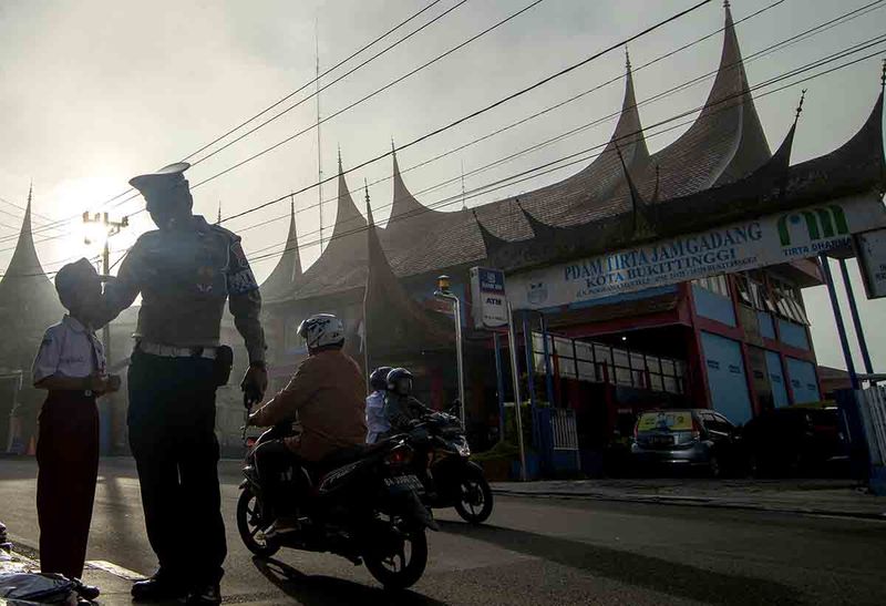 Anggota Polisi Lalu-lintas Polresta Bukittinggi membujuk seorang pelajar Sekolah Dasar (SD) untuk ikut ujian di Bukittinggi, Sumatera Barat, Senin (25/9/2023). Polisi menemukan pelajar SD tersebut menangis di jalan karena malu tidak memiliki plastik pembungkus kartu ujiannya kemudian dibujuk untuk tetap ke sekolah. ANTARA FOTO/Iggoy el Fitra