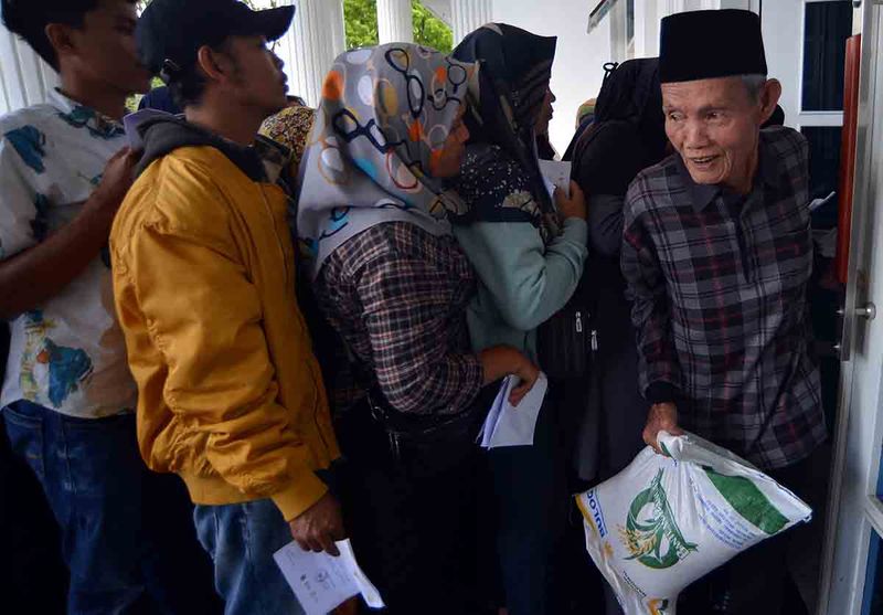 Warga membawa beras yang dibagikan saat penyaluran beras cadangan pangan pemerintah tahap 2 di Bukittinggi, Sumatera Barat, Senin (25/9/2023). Pemerintah menyalurkan beras cadangan pangan tersebut bagi 4.512 kepala keluarga penerima manfaat di kota itu. ANTARA FOTO/Iggoy el Fitra