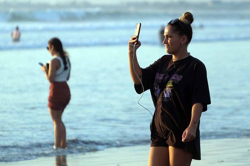 Wisatawan menikmati suasana saat berkunjung di Pantai Kuta, Badung, Bali, Senin (25/9/2023). Kepala Dinas Pariwisata Provinsi Bali Tjok Bagus Pemayun mengatakan untuk retribusi sebesar Rp150 ribu kepada turis asing yang masuk Pulau Dewata diterapkan mulai Februari 2024 dan mekanismenya serta tata cara pungutan uang kepada turis asing hingga saat ini masih disusun dalam Peraturan Gubernur (Pergub) Bali. ANTARA FOTO/Nyoman Hendra Wibowo