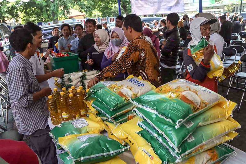 Petugas melayani warga menukarkan kupon bantuan sosial saat operasi gerakan pasar murah dan bansos di Kantor PW Muhammadiyah Jateng, Semarang, Jawa Tengah, Selasa (26/9/2023). Program yang digelar Kementerian Perdagangan, Badan Pangan Nasional, Bulog Jateng, dan PW Muhammadiyah Jateng dengan membagikan bantuan sosial ratusan sak beras berisi 5 kilogram, minyak goreng 1 liter serta mensubsidi berbagai bahan pangan itu untuk membantu warga kurang mampu memenuhi kebutuhan pokok sehari-hari. ANTARA FOTO/Makna Zaezar