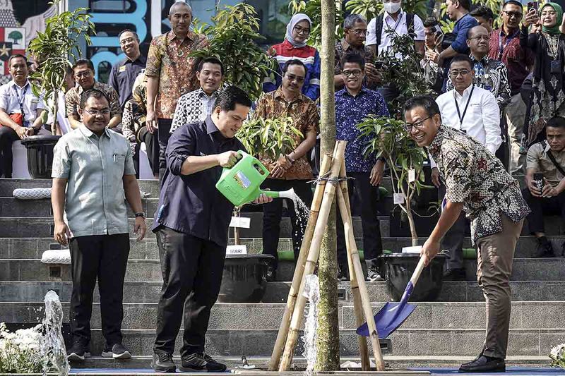 Menteri BUMN Erick Thohir (tengah) didampingi Sekretaris Kementerian BUMN Rabin Indrajad Hattari (kanan) dan Deputi Bidang Sumber Daya Manusia, Teknologi, dan Informasi Kementerian BUMN Tedi Bharata (kiri) menanam pohon saat Program Gotong Royong Boyong Pohon di Kementerian BUMN, Jakarta, Rabu (27/9/2023). Erick Thohir mengatakan penanaman pohon dimulai dari lingkungan kantor BUMN dan seluruh karyawan dengan penanaman 70 ribu pohon secara serentak melalui program tersebut serta mengundang masyarakat untuk berpartisipasi dengan target menanam 30 ribu pohon guna menekan permasalahan polusi di Jakarta. ANTARA FOTO/Dhemas Reviyanto