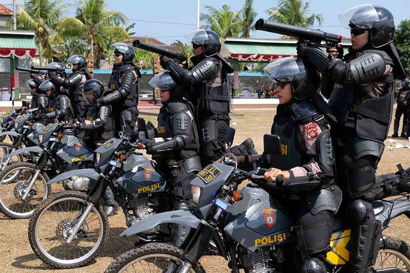 Sejumlah anggota polisi menembakkan gas air mata saat berupaya membubarkan pengunjuk rasa pada simulasi Sistem Pengamanan Kota (Sispamkota) di Lapangan Candradimuka Rindam IX/Udayana, Tabanan, Bali, Rabu (27/9/2023). Kegiatan yang digelar oleh Polres Tabanan tersebut untuk meningkatkan kemampuan penanganan konflik sosial dan kesiapsiagaan anggota Polri, TNI, dan pihak terkait lainnya dalam mengantisipasi gangguan kamtibmas pada Pemilu 2024. ANTARA FOTO/Nyoman Hendra Wibowo