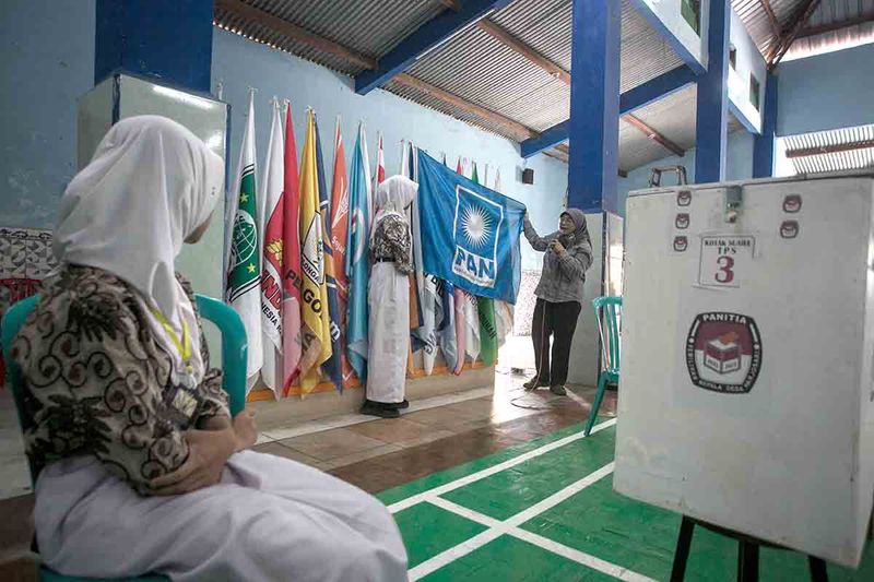 Petugas Komisi Pemilihan Umum (KPU) menunjukkan bendera partai politik pada kegiatan Sosialisasi Pemilu yang bertepatan dengan pemilihan ketua Organisasi Siswa Intra Sekolah (OSIS) dengan sistem Pemilu di SMA I Karangpandan, Karanganyar, Jawa Tengah, Rabu (27/9/2023). Sekolah setempat bekerja sama dengan KPU Karanganyar menggelar pemilihan Ketua OSIS dengan sistem pemungutan suara seperti Pemilu yang bertujuan untuk memberikan edukasi tentang demokrasi dan politik kepada siswa khususnya pemilih pemula. ANTARA FOTO/Mohammad Ayudha