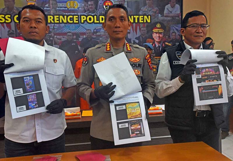 Kabid Humas Polda Banten Kombes Pol Didik Hariyanto (tengah) dibantu staf memperlihatkan barang bukti print akun judi online saat konferensi pers di Mapolda Banten, Serang, Banten, Rabu (27/9/2023). Jajaran Ditreskrimsus Polda Banten menangkap tiga orang tersangka agen yang memasarkan judi secara online dengan mendapat imbalan Rp2 juta per satu akun di sejumlah tempat di Serang. ANTARA FOTO/Asep Fathulrahman