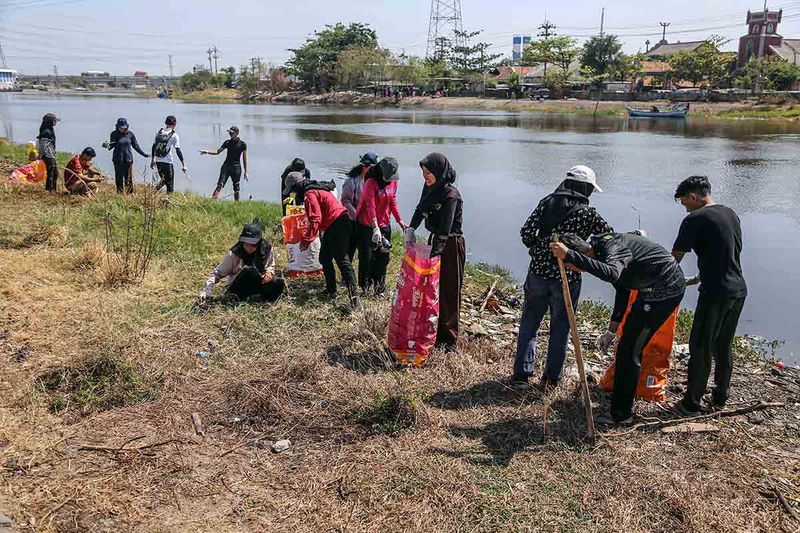 Peserta memungut sampah plastik dan organik saat mengikuti aksi milenial bersih-bersih sampah di bantaran sungai Banjir Kanal Timur Tambakrejo, Semarang, Jawa Tengah, Kamis (28/9/2023). Aksi bersih di bantaran sungai yang melibatkan puluhan mahasiswa dari berbagai universitas dan Dinas Lingkungan Hidup (DLH) kota itu bertujuan menumbuhkan kepedulian masyarakat terhadap lingkungan sekaligus memperingati Hari Bersih Bersih Sedunia. ANTARA FOTO/Makna Zaezar