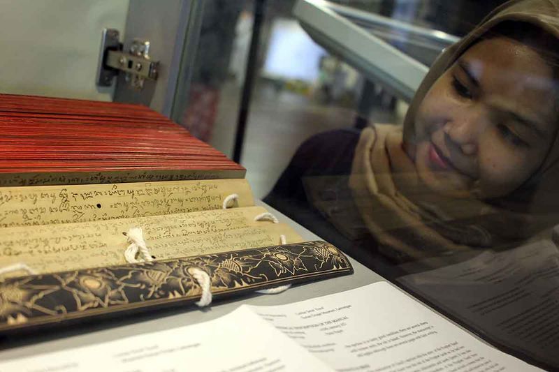 pameran-aksara-di-surabaya-2 Pengunjung mengamati manuskrip yang dipajang pada pameran Aksara di ruang bawah tanah Alun-Alun Surabaya, Jawa Timur, Jumat (29/9/2023). Pameran dalam rangka memperingati Hari Aksara Internasional dengan mengangkat tema Membingkai Aksara Nusantara dan Dunia dari Surabaya tersebut menampilkan sembilan aksara nusantara dan enam aksara dari negara lain. ANTARA FOTO/Didik Suhartono