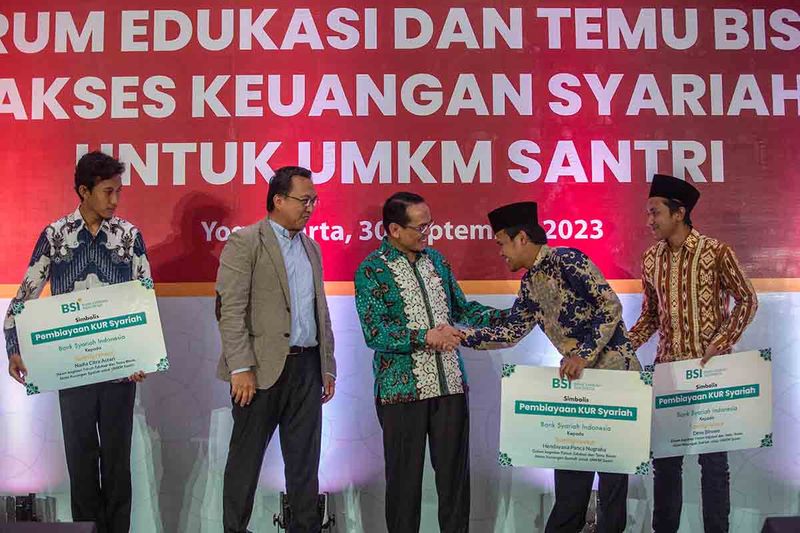 Kepala Eksekutif Pengawas Lembaga Pembiayaan, Perusahaan Modal Ventura, Lembaga Keuangan Mikro dan Lembaga Jasa Keuangan OJK Agusman (tengah) didampingi SPV Micro Banking BSI Joni Haryanto (dua kiri) memberikaan pembiayaan KUR syariah pada acara Forum Edukasi dan Temu Bisnis Akses Keuangan Syariah untuk UMKM Santri di UIN Sunan Kalijaga, Sleman, DI Yogyakarta, Sabtu (30/9/2023). Dalam kegiatan tersebut OJK mendorong peningkatan literasi dan inklusi keuangan syariah untuk meningkatkan kualitas hidup dan kesejahteraan masyarakat melalui peranan santri. ANTARA FOTO/Hendra Nurdiyansyah