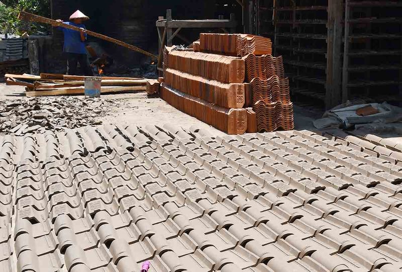 Perajin membakar genteng di Gulun, Magetan, Jawa Timur, Sabtu (30/9/2023). Menurut perajin produksi genteng yang dijual Rp1.000-Rp1.250 per biji itu pada musim kemarau meningkat dari biasanya 200 biji menjadi 300 biji per hari karena proses pengeringan lebih cepat. ANTARA FOTO/Siswowidodo