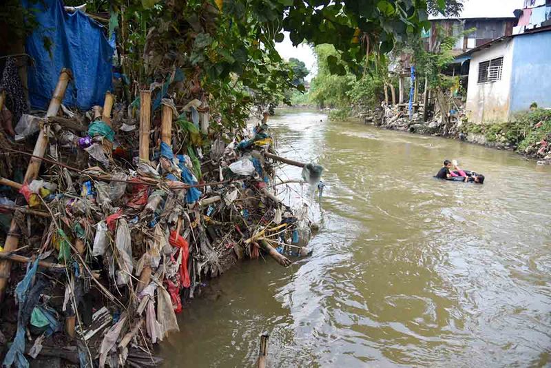 Sejumlah anak bermain di aliran Sungai Deli yang sisinya dipenuhi sampah, di Medan, Sumatera Utara, Sabtu (30/9/2023). Pemerintah Kota Medan akan memberikan sanksi denda Rp10 juta atau tiga bulan penjara kepada warga yang membuang sampah sembarangan ke Sungai Deli mulai Januari 2024. ANTARA FOTO/Fransisco Carolio