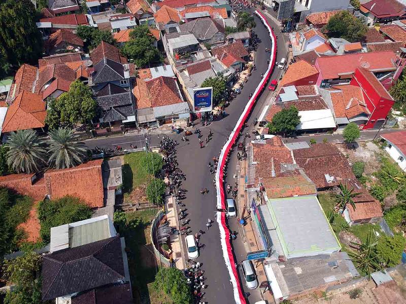 Foto udara sejumlah peserta berjalan membawa bendera saat Kirab Merah Putih di Kabupaten Batang, Jawa Tengah, Minggu (1/10/2023). Kirab merah putih dalam rangka memperingati Hari Kesaktian Pancasila itu, diikuti sekitar 4.500 orang yang mengarak foto pahlawan revolusi dan bendera merah putih sepanjang sekitar satu kilometer yang bertujuan untuk mengenang jasa pahlawan revolusi dan meningkatkan ideologi bangsa kepada seluruh lapisan masyarakat. ANTARA FOTO/Harviyan Perdana Putra