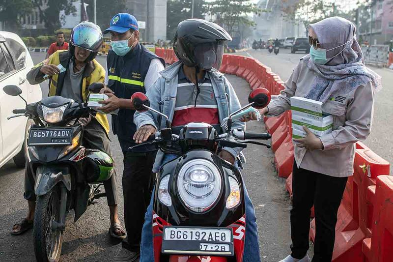 Petugas dari Dinas Kesehatan Provinsi Sumatera Selatan membagikan masker kepada pengendara di simpang lima DPRD Provinsi Sumatera Selatan, Palembang, Minggu (1/10/2023). Dinkes Provinsi Sumatera Selatan membagikan 3,7 juta masker kepada masyarakat untuk mencegah terjangkitnya penyakit Infeksi Saluran Pernapasan Akut ( ISPA) akibat bencana kabut asap di Palembang dampak Kebakaran Hutan dan Lahan (Karhutla) yang terjadi di sejumlah Kabupatan/Kota yang ada di Sumatera Selatan. ANTARA FOTO/Nova Wahyudi