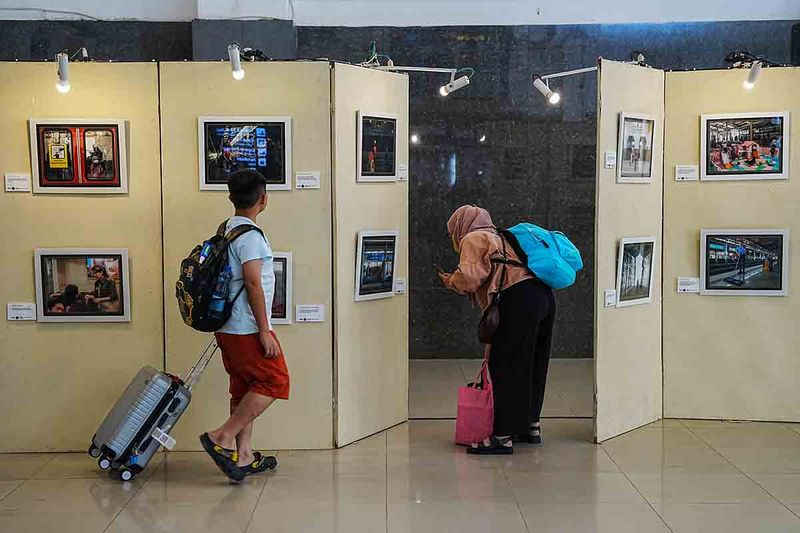 Pengunjung mengamati foto yang dipajang pada pameran bertajuk Aktivitas Stasiun di kawasan Stasiun Balapan Solo, Jawa Tengah, Minggu (1/10/2023). Pameran foto oleh komunitas Fujiguys Indonesia Solo tersebut juga diisi dengan diskusi dan praktik fotografi guna merayakan Hari Kereta Api Nasional. ANTARAFOTO/Maulana Surya