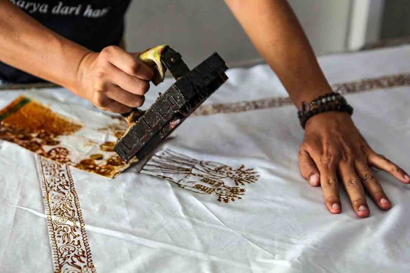 Perajin menyelesaikan produksi batik cap di Rumah Batik Palbatu, Tebet, Jakarta, Minggu (1/10/2023). Rumah Batik Palbatu didirikan untuk mengedukasi masyarakat mengenai batik sekaligus memproduksi batik yang dijual dengan harga Rp 250 ribu hingga Rp 850 ribu per lembar kain tergantung proses membatiknya itu dipasarkan keberbagai daerah dan secara daring melalui toko digital. ANTARA FOTO/Asprilla Dwi Adha