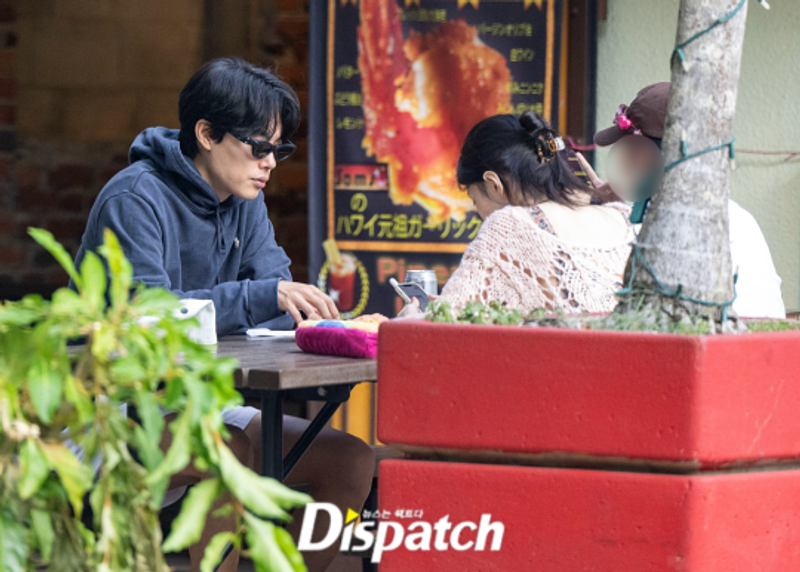 Han Sohee fokus ke ponselnya sementara Ryu Junyeol fokus kepada hidangan di hadapannya. Sumber: Dispatch